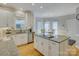 Bright kitchen boasts white cabinets, granite counters, stainless appliances, and a central island cooktop at 15824 Feeny Ct, Charlotte, NC 28278