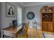 Well-lit home office featuring a wooden desk and hardwood floors, complete with a bookshelf and decor at 15824 Feeny Ct, Charlotte, NC 28278