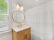 Bright bathroom featuring a light-wood vanity, a round mirror, and modern fixtures at 1614 Brook Rd, Charlotte, NC 28205