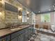 Elegant bathroom with double vanities, granite countertops, patterned wallpaper, and marble tile at 1614 Brook Rd, Charlotte, NC 28205
