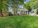 Charming home featuring a manicured lawn, a light gray roof, white trim and a welcoming front porch at 1614 Brook Rd, Charlotte, NC 28205