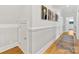Bright hallway with hardwood floors, wainscoting, and classic New Yorker magazine covers at 1614 Brook Rd, Charlotte, NC 28205