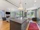 Open concept kitchen with island, farmhouse sink, and view to the living room with fireplace at 1614 Brook Rd, Charlotte, NC 28205