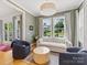 Bright living room with large windows overlooking the landscaped backyard, offering a cozy seating area at 1614 Brook Rd, Charlotte, NC 28205