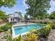 Refreshing in-ground swimming pool surrounded by lush landscaping and lounge chairs at 1614 Brook Rd, Charlotte, NC 28205