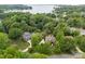 Picturesque aerial view of a lakeside home surrounded by lush trees and a serene lake, offers privacy at 21305 Sandy Cove Rd, Cornelius, NC 28031