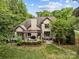 Aerial view of a home showcasing the backyard with a patio, pergola, and mature trees at 21305 Sandy Cove Rd, Cornelius, NC 28031
