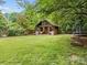 Spacious backyard with a playhouse, swing and lush greenery, perfect for outdoor activities at 21305 Sandy Cove Rd, Cornelius, NC 28031