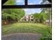Spacious backyard with lush lawn, mature trees, stone patio, and pergola, perfect for entertaining or relaxing outdoors at 21305 Sandy Cove Rd, Cornelius, NC 28031