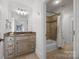 Bathroom features a shower-tub combo with tile surround, vanity, and neutral finishes at 21305 Sandy Cove Rd, Cornelius, NC 28031
