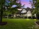 Beautiful stone home with a well-manicured lawn and lush landscaping showcasing its curb appeal at 21305 Sandy Cove Rd, Cornelius, NC 28031