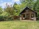 Quaint guest house with a covered porch, stone accents, and a well-maintained lawn at 21305 Sandy Cove Rd, Cornelius, NC 28031