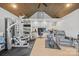 Bright home gym with hardwood floors, modern equipment, and built-in shelving for organized storage and functionality at 21305 Sandy Cove Rd, Cornelius, NC 28031