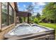 Hot tub with water feature on a patio surrounded by landscaped backyard and lush trees at 21305 Sandy Cove Rd, Cornelius, NC 28031