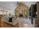Open living room with a soaring stone fireplace, hardwood floors, and ample seating at 21305 Sandy Cove Rd, Cornelius, NC 28031