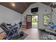 Exercise room with wood ceiling, workout equipment, tv, and access to the backyard at 21305 Sandy Cove Rd, Cornelius, NC 28031