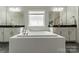 A luxurious bathroom featuring a large soaking tub and granite-topped vanities at 2164 Hanging Rock Rd, Fort Mill, SC 29715
