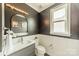Chic powder room with modern fixtures, elegant mirror, and a wainscoted wall at 2164 Hanging Rock Rd, Fort Mill, SC 29715
