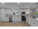 Modern kitchen features stainless appliances, quartz countertops, white cabinetry and woodgrain floors at 322 Corriher Heights Ave, China Grove, NC 28023