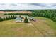 Aerial view showcases multiple outbuildings and lush greenery, highlighting the property's potential at 3400 Baucom Manor Rd, Monroe, NC 28110
