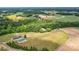 Areal view of a sprawling estate featuring lush pasture land, barns, trees, and a home at 3400 Baucom Manor Rd, Monroe, NC 28110