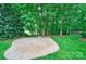 Spacious stamped concrete patio surrounded by lush green grass and mature trees in the backyard at 3400 Baucom Manor Rd, Monroe, NC 28110