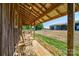 Covered porch with charming wooden chairs offering views of the surrounding pasture and barn at 3400 Baucom Manor Rd, Monroe, NC 28110