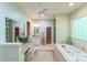Airy bathroom featuring a soaking tub, vanity with granite countertops, and neutral-toned tile flooring at 3400 Baucom Manor Rd, Monroe, NC 28110
