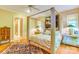 Elegant bedroom with a four-poster bed, hardwood floors, and natural light from windows at 3400 Baucom Manor Rd, Monroe, NC 28110