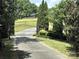 Gated entrance leads to a private driveway surrounded by mature trees and lush greenery at 3400 Baucom Manor Rd, Monroe, NC 28110