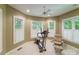 Bright exercise room with large windows, plantation shutters, ceiling fan, and workout equipment at 3400 Baucom Manor Rd, Monroe, NC 28110