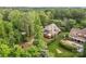 Aerial view of a stately home surrounded by lush greenery, a large deck, and manicured landscaping at 4563 Osprey Run Ct, Denver, NC 28037