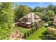 Expansive aerial view of a brick home, showcasing the deck, landscaping, and verdant surroundings at 4563 Osprey Run Ct, Denver, NC 28037