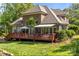 Expansive backyard view of the brick home, showcasing a spacious deck and lush lawn at 4563 Osprey Run Ct, Denver, NC 28037