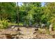 Secluded backyard fire pit area with Adirondack chairs, nestled amongst mature trees at 4563 Osprey Run Ct, Denver, NC 28037