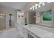 Bright bathroom with double sinks, vanity with marble countertop, walk-in closet and tub with large mirror at 4563 Osprey Run Ct, Denver, NC 28037