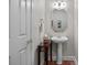 Charming powder room featuring hardwood floors, a pedestal sink and a decorative mirror with white door and trim at 4563 Osprey Run Ct, Denver, NC 28037