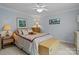 Cozy bedroom with neutral walls, a ceiling fan, a comfortable bed with plush bedding, and bedside tables at 4563 Osprey Run Ct, Denver, NC 28037
