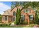 Stately brick home featuring arched windows, manicured landscaping, and a welcoming entrance at 4563 Osprey Run Ct, Denver, NC 28037