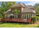 Rear view of brick home featuring a spacious deck, well-manicured lawn, and mature landscaping at 4563 Osprey Run Ct, Denver, NC 28037