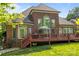 Back of a brick home featuring a large deck, lush lawn, and mature landscaping at 4563 Osprey Run Ct, Denver, NC 28037