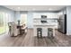 Bright kitchen with white cabinets, stainless steel appliances, an island with barstool seating, and an adjacent dining area at 5224 Mccallum Meadows Dr, Charlotte, NC 28216
