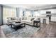 Open-concept living room featuring contemporary furnishings, wood floors, and seamless flow into the kitchen and dining area at 5224 Mccallum Meadows Dr, Charlotte, NC 28216