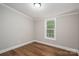Bedroom featuring wood-look floors, and a large window allowing natural light at 5376 Walter Estate Ln, Iron Station, NC 28080