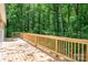 Wooden deck with railings surrounded by beautiful green trees at 5376 Walter Estate Ln, Iron Station, NC 28080