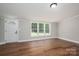 Bright living room featuring wood-look flooring, a front door and large window allowing natural light at 5376 Walter Estate Ln, Iron Station, NC 28080