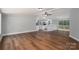 Open concept living room with wood floors adjacent to a kitchen featuring white cabinets at 5376 Walter Estate Ln, Iron Station, NC 28080