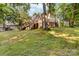 View of the backyard featuring a covered patio, elevated deck and mature trees at 552 Blue Rock Dr, Charlotte, NC 28213