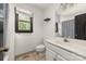 White bathroom featuring a single sink vanity, black trimmed window and neutral tile flooring at 552 Blue Rock Dr, Charlotte, NC 28213