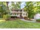 Charming two-story home featuring a double porch and inviting curb appeal surrounded by mature trees at 552 Blue Rock Dr, Charlotte, NC 28213